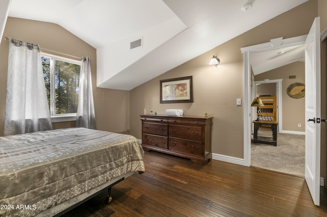 bedroom with lofted ceiling and dark hardwood / wood-style floors