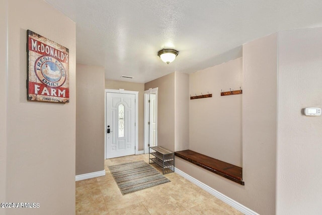 foyer featuring a textured ceiling and light tile patterned flooring