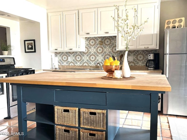 kitchen featuring tasteful backsplash, white cabinetry, wooden counters, and stainless steel appliances