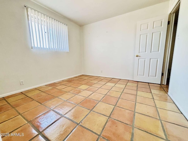 unfurnished room featuring baseboards and light tile patterned flooring