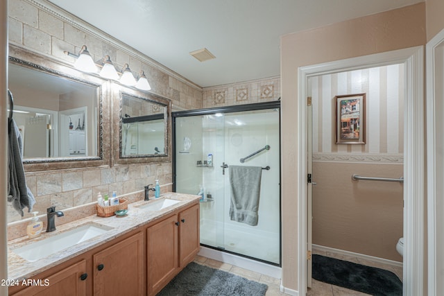 bathroom featuring tile patterned floors, backsplash, toilet, and a shower with door