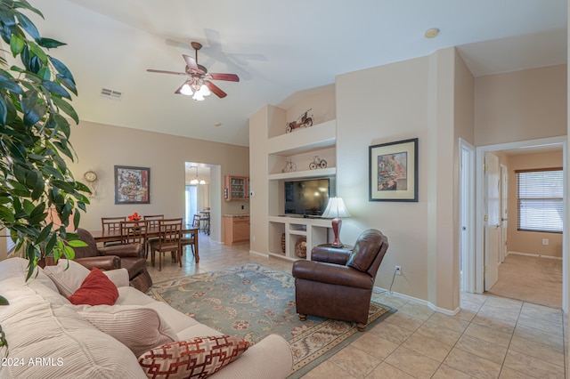 living room with built in shelves, ceiling fan, light tile patterned floors, and vaulted ceiling