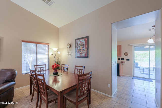 dining space with light tile patterned floors and vaulted ceiling