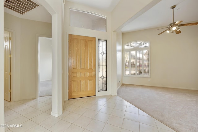 carpeted foyer featuring a high ceiling and ceiling fan