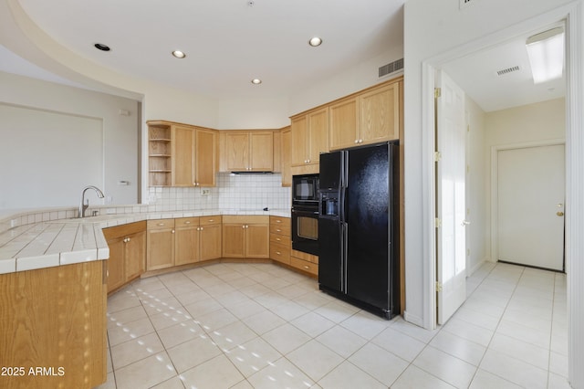 kitchen featuring tile countertops, tasteful backsplash, sink, light tile patterned floors, and black appliances