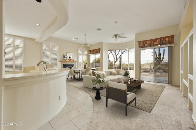 living room featuring sink, ceiling fan, and light tile patterned flooring