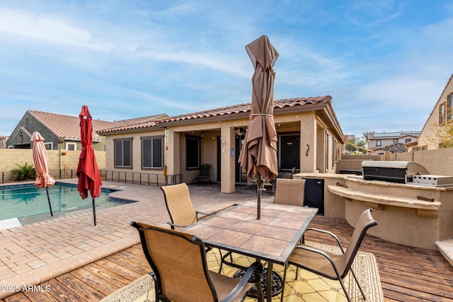 back of property with area for grilling, a patio area, and a fenced in pool