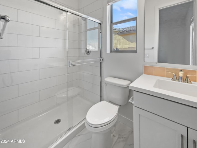 bathroom featuring a shower with door, vanity, and toilet