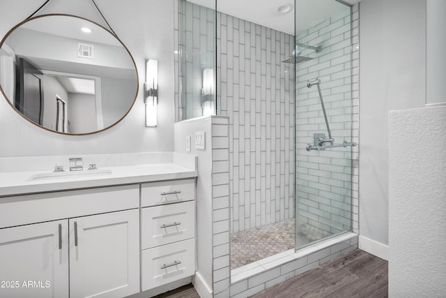 9340 N 92nd St Unit 118, Scottsdale, AZ 85258 - bathroom with wood finished floors, vanity, visible vents, recessed lighting, and tiled shower