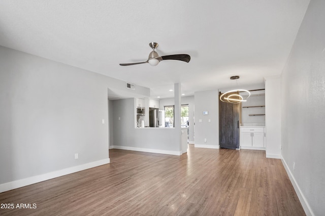 9340 N 92nd St Unit 118, Scottsdale, AZ 85258 - unfurnished living room featuring baseboards, visible vents, wood finished floors, and a ceiling fan