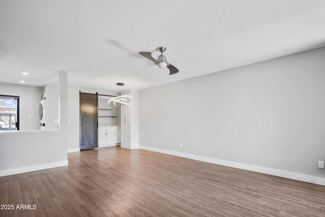 9340 N 92nd St Unit 118, Scottsdale, AZ 85258 - unfurnished living room featuring wood finished floors, a barn door, baseboards, ceiling fan, and recessed lighting