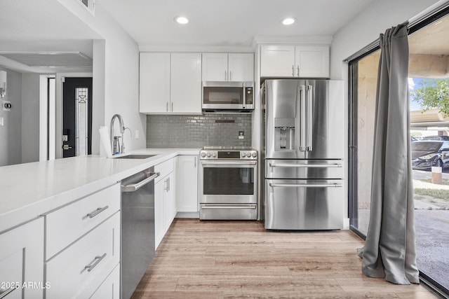 9340 N 92nd St Unit 118, Scottsdale, AZ 85258 - kitchen featuring a sink, light wood-type flooring, light countertops, appliances with stainless steel finishes, and recessed lighting