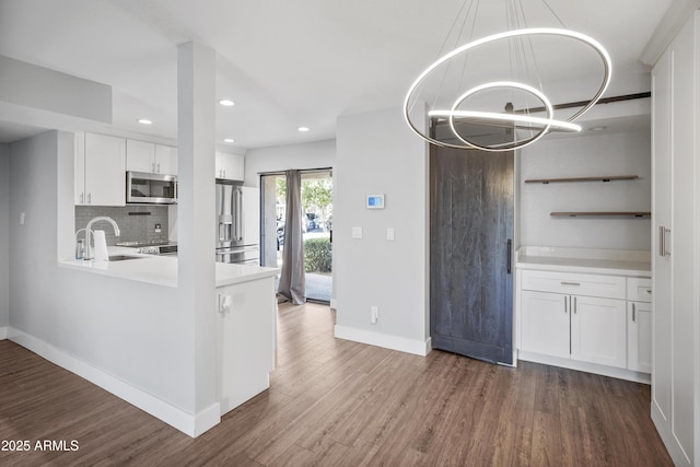 9340 N 92nd St Unit 118, Scottsdale, AZ 85258 - kitchen featuring a chandelier, dark wood-style floors, white cabinets, baseboards, and appliances with stainless steel finishes
