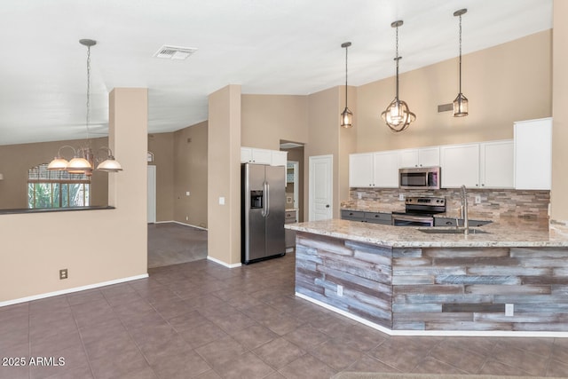 5733 E Jaeger St, Mesa, AZ 85205 - kitchen with appliances with stainless steel finishes, tasteful backsplash, a chandelier, white cabinets, and light stone counters