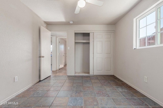 unfurnished bedroom featuring ceiling fan and a closet