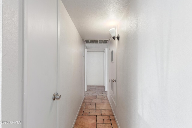 hall featuring a textured ceiling