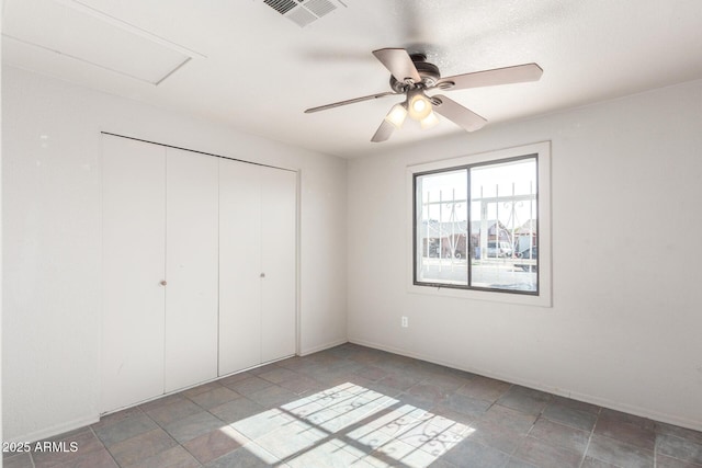 unfurnished bedroom featuring ceiling fan and a closet