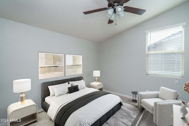 bedroom featuring ceiling fan, light carpet, and vaulted ceiling