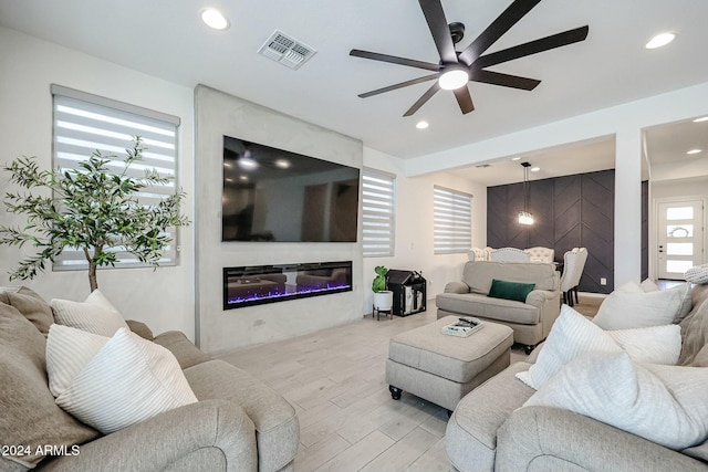 18813 W Solano Dr, Litchfield Park, AZ 85340 - living room featuring wood finished floors, a ceiling fan, a glass covered fireplace, and recessed lighting