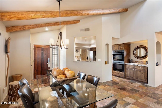 dining area with beam ceiling, a notable chandelier, and a high ceiling