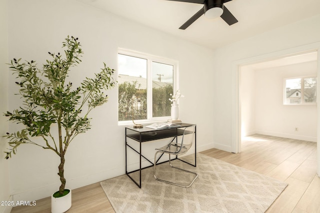 office area with baseboards, ceiling fan, and wood finished floors