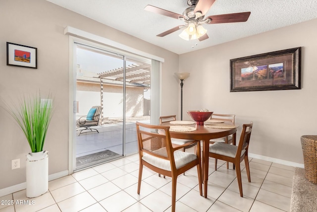 dining area with ceiling fan, a textured ceiling, baseboards, and light tile patterned floors