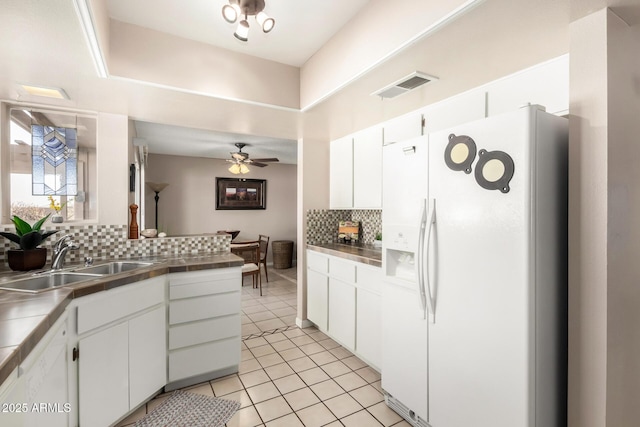 kitchen featuring tasteful backsplash, visible vents, a sink, ceiling fan, and white fridge with ice dispenser