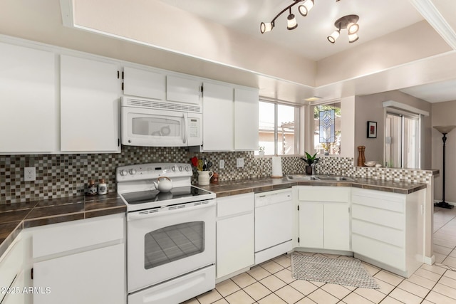 kitchen with white appliances, a sink, white cabinetry, and decorative backsplash