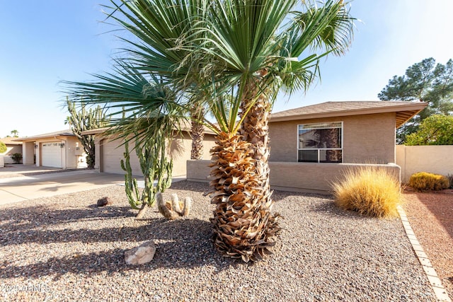 view of front of property featuring driveway, an attached garage, and stucco siding