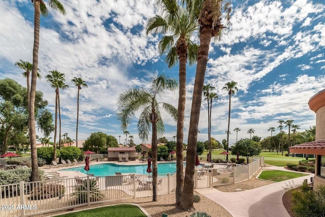 pool with a patio area and fence