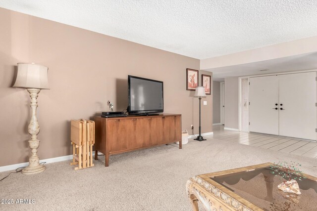 living room with light carpet, a textured ceiling, baseboards, and light tile patterned floors