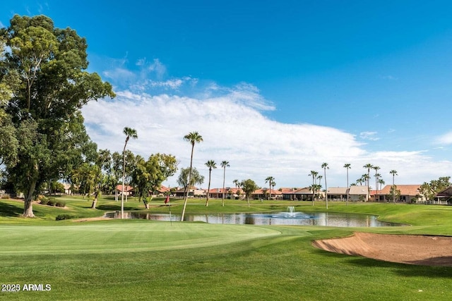 view of property's community featuring a water view, a lawn, and golf course view