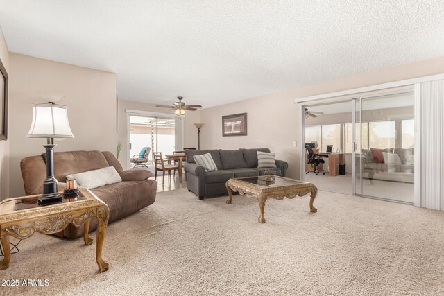 carpeted living area featuring a textured ceiling and a ceiling fan