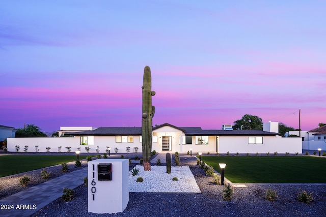 ranch-style home with a lawn