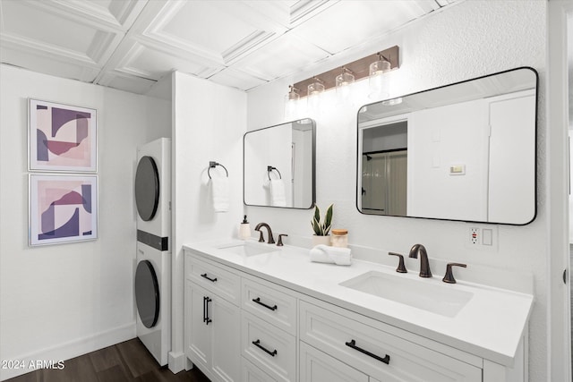 bathroom with wood-type flooring, stacked washer / dryer, coffered ceiling, vanity, and beam ceiling