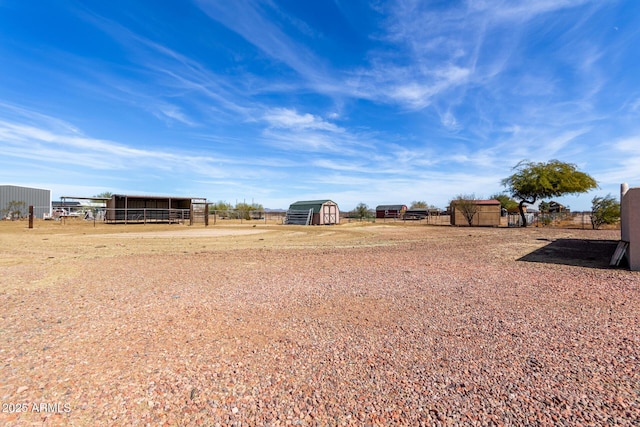 view of yard with an outdoor structure and a rural view