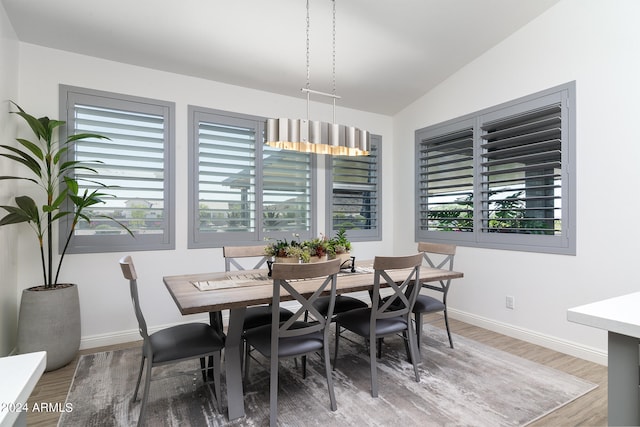 dining room featuring vaulted ceiling and wood-type flooring