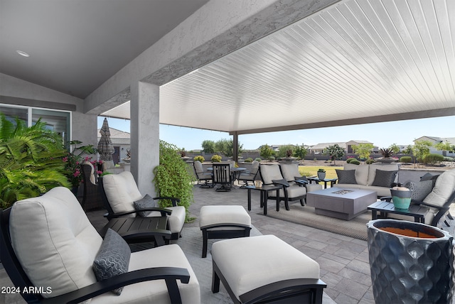 view of patio with an outdoor living space with a fire pit