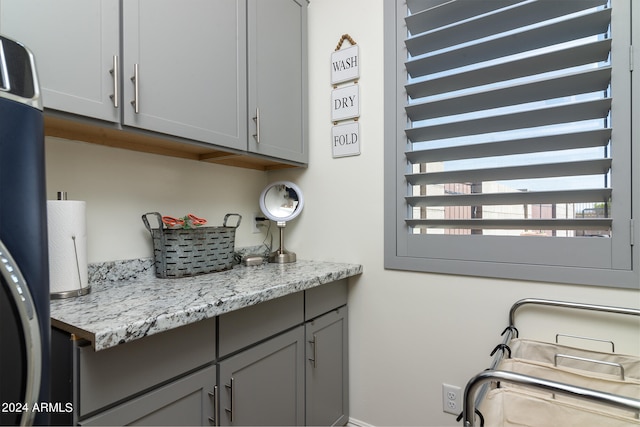 clothes washing area with cabinets