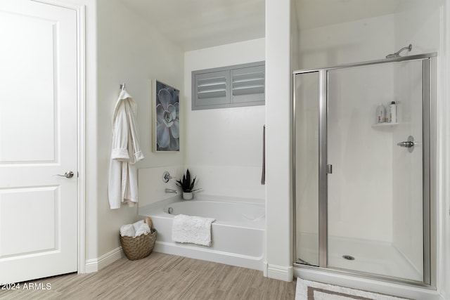 bathroom featuring independent shower and bath and hardwood / wood-style floors