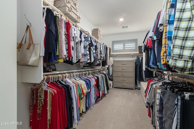 walk in closet with light colored carpet