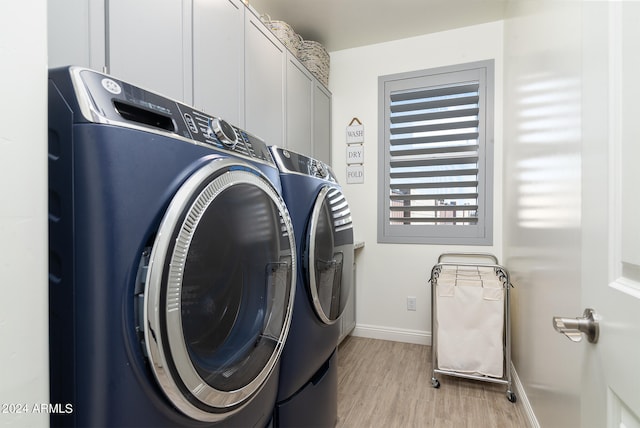 laundry area with washer and clothes dryer, cabinets, and light hardwood / wood-style flooring