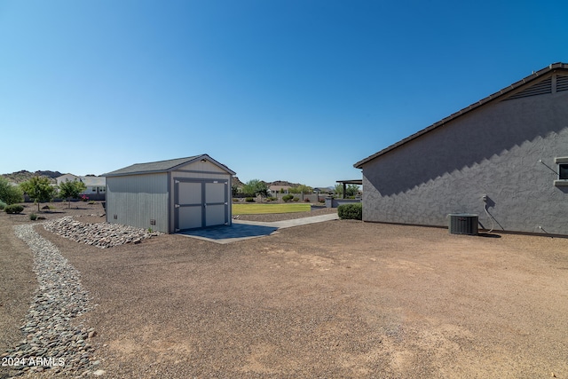 view of yard featuring central air condition unit and a storage shed