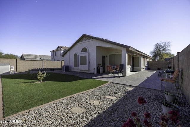 rear view of property featuring a lawn, central air condition unit, and a patio