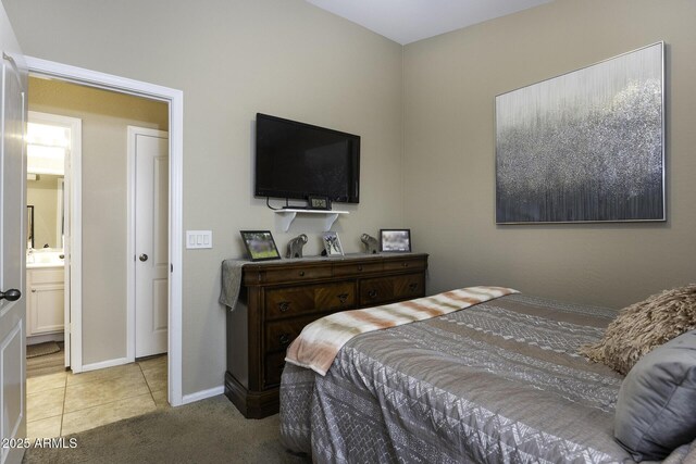 bedroom featuring ensuite bathroom and light tile patterned flooring