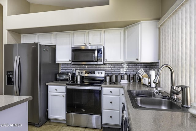 kitchen featuring sink, stainless steel appliances, light tile patterned floors, tasteful backsplash, and white cabinets