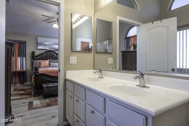 bathroom with hardwood / wood-style floors, ceiling fan, and vanity