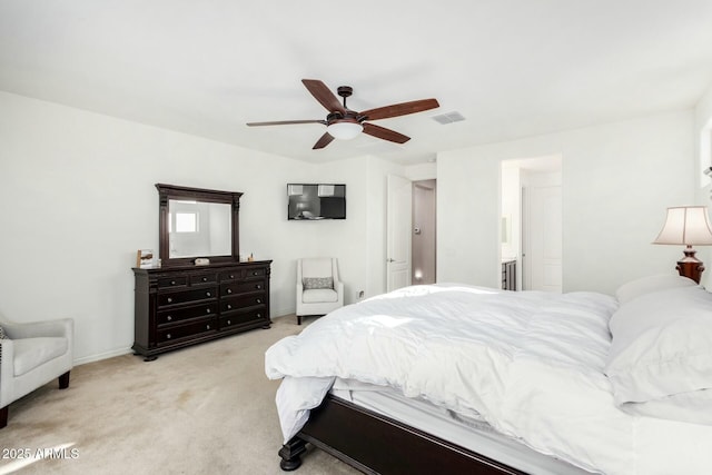 bedroom featuring light colored carpet, ensuite bath, and ceiling fan