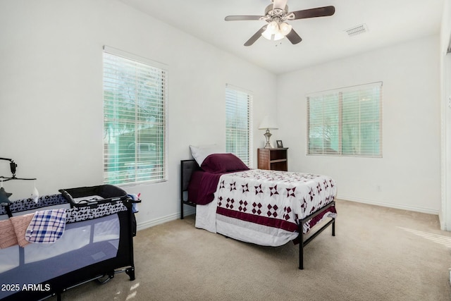 carpeted bedroom with multiple windows and ceiling fan