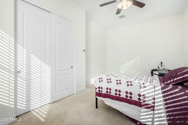 bedroom featuring ceiling fan, a closet, and light carpet